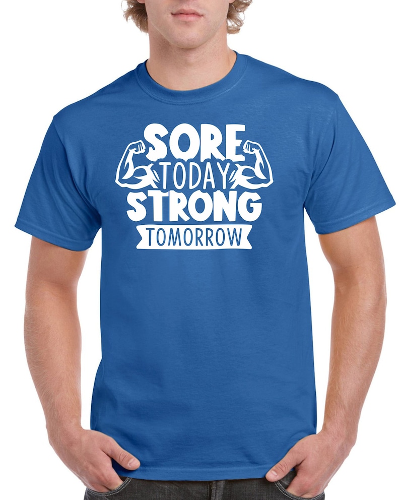 May include: A royal blue t-shirt with white text that reads "Sore Today Strong Tomorrow" with a graphic of two white bicep muscles.