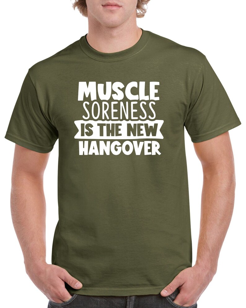 May include: A green t-shirt with white text that reads "Muscle Soreness Is The New Hangover".