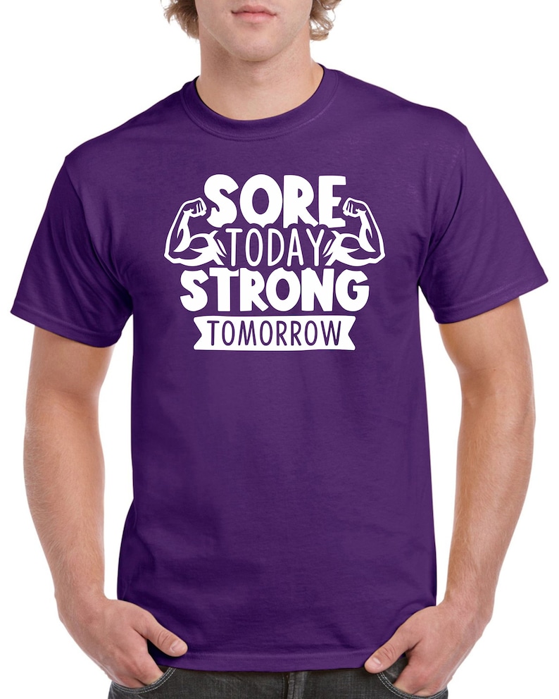 May include: Purple t-shirt with white text that reads "Sore Today Strong Tomorrow" with a graphic of two bicep muscles.