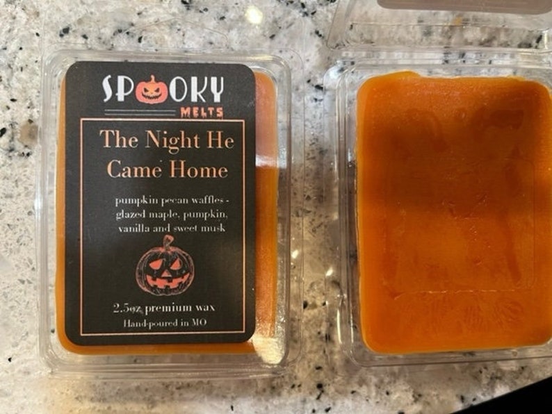May include: A 2.5 ounce wax melt in a clear plastic container with a black label that reads "SPOOKY MELTS" and "The Night He Came Home". The label also includes a pumpkin illustration and the text "pumpkin pecan waffles, glazed maple, pumpkin, vanilla and sweet musk".