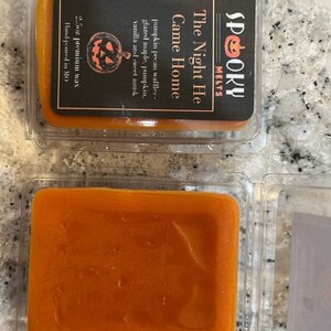 May include: A 2.5 ounce candle in a clear plastic container with a black label that reads "Spooky Melts" and "The Night He Came Home". The candle is a pumpkin spice scent with notes of pecan waffles, glazed maple, pumpkin, vanilla, and sweet musk. The candle is hand-poured in Missouri.