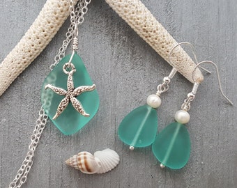 May include: A teal sea glass necklace and earrings set with a silver starfish charm and white pearl accents.