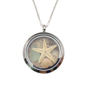 May include: A silver locket necklace with a clear glass insert containing sand, a seashell, and a starfish.