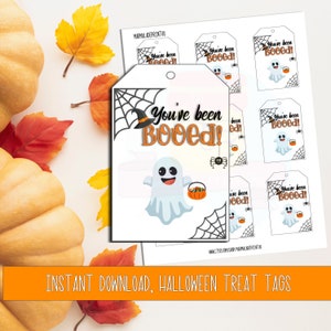 Può includere: Etichette per dolcetti di Halloween stampabili con un fantasma che tiene un cestino di caramelle e il testo "You've been Booed!" Le etichette sono progettate con una ragnatela e un cappello da strega.