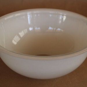 May include: A white, opaque, round bowl with a smooth, slightly curved rim.
