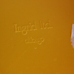 Op de afbeelding: Close-up van een geel oppervlak met de tekst "Ingrid Ltd. Chicago" erop gegraveerd.