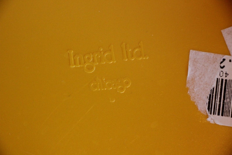 Op de afbeelding: Close-up van een geel oppervlak met de tekst "Ingrid Ltd. Chicago" erop gegraveerd.