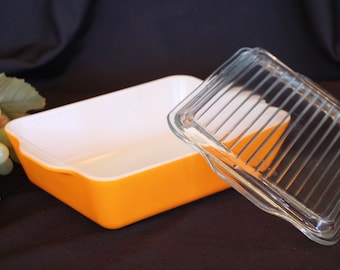 May include: Orange glass baking dish with a clear glass lid. The lid has a raised, ridged design.