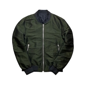 Può includere: Una tazza di ceramica bianca con manico nero e la scritta "But First, Coffee" in grassetto nero. La tazza è piena di un liquido scuro, probabilmente caffè, e poggia su una superficie chiara.