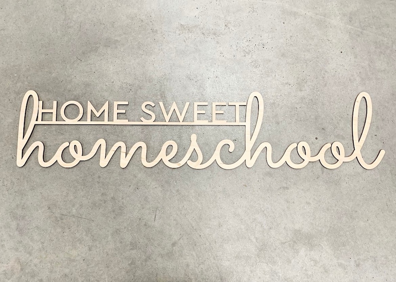 K&ouml;nnte beinhalten: Helles Holzschild mit dem Schriftzug "HOME SWEET homeschool" in Schreibschrift. Das Wort "HOME SWEET" ist in Blockschrift gehalten. Ein dekoratives Element f&uuml;r das Kinderzimmer oder den Arbeitsbereich.