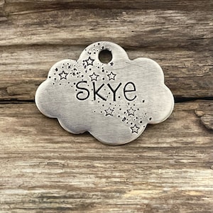 May include: Silver cloud-shaped dog tag with the name "Skye" engraved on it. The tag is decorated with a scattering of small stars.