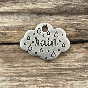 May include: Silver charm shaped like a cloud with the word "rain" and raindrops engraved on it.