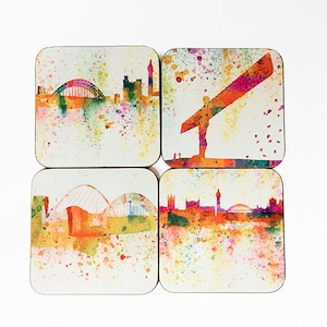 Può includere: Set di quattro sottobicchieri quadrati con paesaggi urbani in stile acquerello. Ogni sottobicchiere rappresenta un monumento diverso, tra cui un ponte, una statua e uno skyline. I sottobicchieri hanno uno sfondo bianco con schizzi di vernice colorati.
