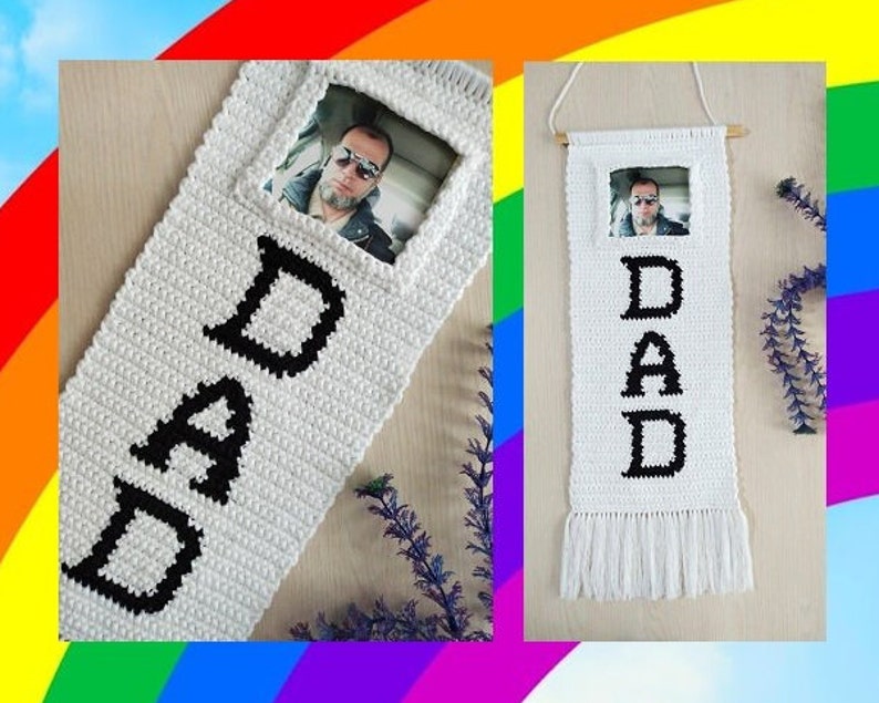 May include: White crocheted wall hanging with the word "DAD" spelled out in black yarn. A photo is inserted into a frame at the top of the hanging.