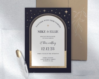 May include: A wedding invitation with a navy blue background and gold accents. The invitation includes the names "Mike & Ellie" and the date "12.12.23". A kraft paper envelope is behind the invitation. A white feather with a gold tip is in the foreground.