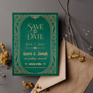 May include: Emerald green "Save the Date" wedding invitation with gold lettering and decorative border. The invitation includes the date "June 7, 2024" and the names "Laura & Joseph". A brown envelope and dried flowers are also in the image.