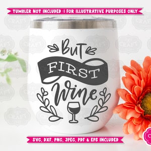 May include: A white stemless wine tumbler with a silver rim. The tumbler features the phrase "But First Wine" in black script and a wine glass graphic. Decorative floral elements surround the text. The image includes a bright orange flower.