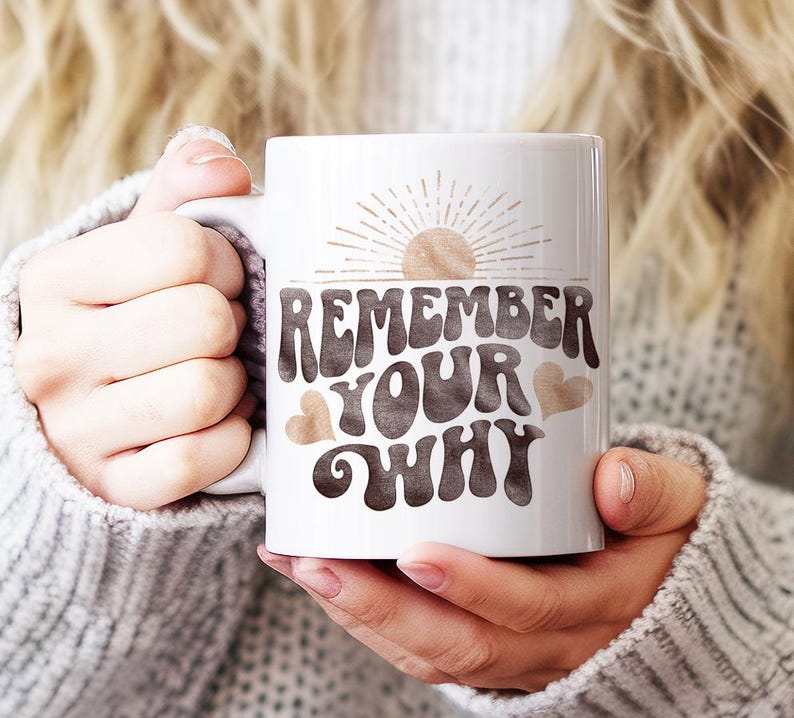 May include: White ceramic mug with a brown and white graphic that says "Remember Your Why" with a sun and hearts.