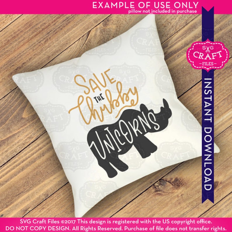 Puede incluir: Una almohada blanca con el texto "Save the Chibby Unicorns" en letras doradas. El texto est&aacute; escrito en una fuente caprichosa y est&aacute; acompa&ntilde;ado por una silueta negra de un rinoceronte.