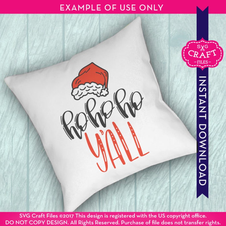 Puede incluir: Una almohada blanca con un gorro de Pap&aacute; Noel rojo y el texto "ho ho ho y'all" en letras negras y rojas.
