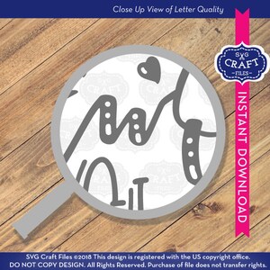 May include: Close-up view of a magnifying glass showing the quality of a digital design file for a craft project. The design is a handwritten word "Art" with a heart and a small design element. The text "SVG Craft Files" is repeated in the background.