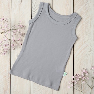 Könnte beinhalten: Ein graues ärmelloses Tanktop aus weicher Baumwolle. Das Tanktop hat ein schlichtes Design mit einem runden Ausschnitt und keine Verzierungen.
