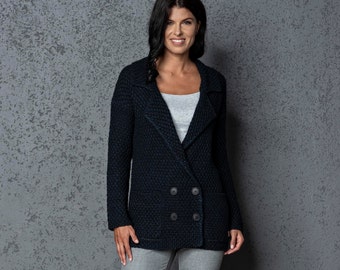 May include: A dark blue knitted cardigan with a double-breasted closure and two pockets. The cardigan has a textured pattern and is worn by a person with long dark hair.