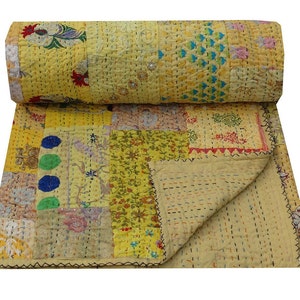 May include: A yellow kantha quilt with a patchwork design featuring various floral and geometric patterns in shades of yellow, green, blue, red, and pink. The quilt is made of cotton and has a hand-stitched design.