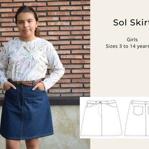 May include: A denim skirt with a front pocket and a back pocket. The skirt is a dark blue color and has a brown belt. The skirt is shown on a model wearing a white tie-dye shirt. The text "Sol Skirt" and "Girls Sizes 3 to 14 years old" is shown in the image.