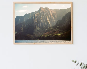 May include: A framed photograph of a mountain range with a green and brown color scheme. The mountains are reflected in the water below.