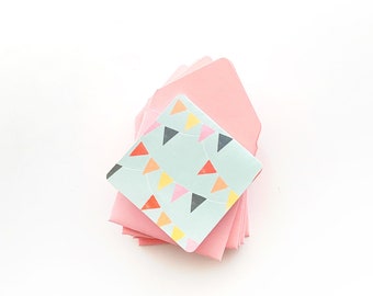 May include: A stack of pink envelopes with a light blue envelope with a colorful triangle pattern on top.