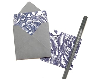 May include: A gray envelope with a floral patterned card inside. A black pen is also included.