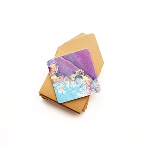 May include: A stack of brown envelopes with a single card on top. The card has a purple, blue, and gold abstract design.