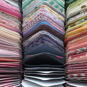 May include: A collection of colorful patterned paper cards stacked in rows. The cards are arranged in a rainbow pattern, with each row featuring a different color and pattern.