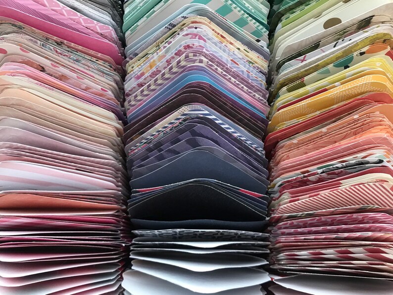 May include: A collection of colorful patterned paper cards stacked in rows. The cards are arranged in a rainbow pattern, with each row featuring a different color and pattern.