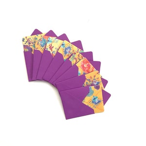 May include: A set of ten purple envelopes with yellow floral patterned fronts. The envelopes are arranged in a fan shape.