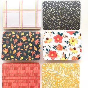 May include: Six rectangular cards with rounded corners, each featuring a unique pattern. Designs include a plaid, gold dots on navy, autumn leaves, floral, vertical lines, and white tropical leaves on yellow.