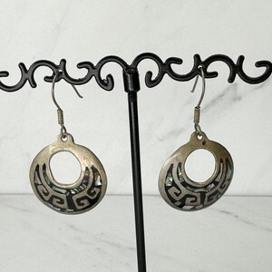 Pendientes colgantes vintage mexicanos con incrustaciones de concha de abulón en tono plateado, perforados, con diseño de greca griega y detalles en negro.