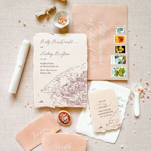 May include: Wedding invitation suite with a hand-drawn illustration of a coastal town. The invitation is on textured paper with a peach envelope. The invitation reads "Melly MacDonald and Zachary McJener to wed the fifth of October two thousand twenty-two Hotel Marincanto Positano, Italy". The RSVP card reads "Join us for seconde dinner and dancing immediately following the ceremony".