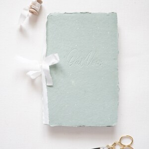 Green handmade paper book with blind (no) letterpress ink