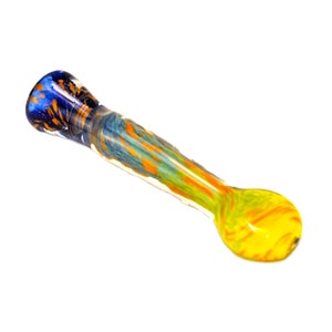 Peut inclure: Une pipe en verre colorée avec un foyer arrondi jaune et des tourbillons orange, menant à une tige avec des motifs verts, oranges et bleus. L'embout buccal est bleu avec des mouchetures orange.