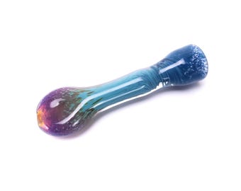 May include: A colorful glass pipe with a rounded bowl and a long, slender stem. The bowl transitions from purple to orange and green, while the stem is a mix of blue and teal. The mouthpiece is a darker blue with a textured surface.