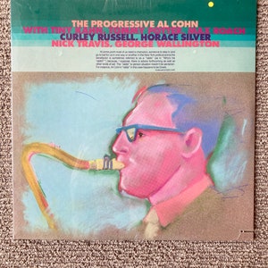 May include: A vintage vinyl record cover featuring a colorful illustration of a man playing a saxophone. The cover is titled "The Progressive Al Cohn" and features the names of other musicians including "Tiny Kahn, Tommy Potter, Max Roach, Curley Russell, Horace Silver, Nick Travis, and George Wallington".