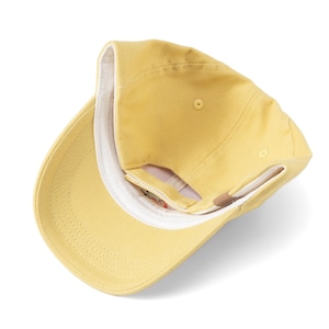 May include: A yellow baseball cap with a white inner lining. The cap is turned inside out, showing the inside of the cap.
