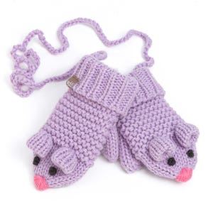 May include: A pair of lavender knitted mittens with a mouse design. The mittens have black eyes, pink noses, and small ears. A knitted cord connects the mittens. A small brown tag is attached to one mitten.