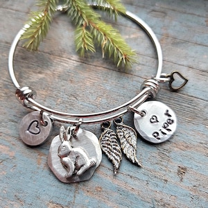 K&ouml;nnte beinhalten: Silberarmband mit einem Herz-, einem Hasen-, einem Fl&uuml;gel- und einem Anh&auml;nger mit der Aufschrift "Riper".