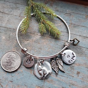 K&ouml;nnte beinhalten: Silbernes Armband mit einem Herz-, einem Hasen-, einem Fl&uuml;gel- und einem personalisierten Anh&auml;nger mit der Aufschrift "Piper".