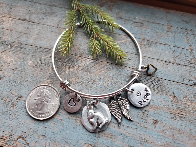 K&ouml;nnte beinhalten: Silbernes Armband mit einem Herz-, einem Hasen-, einem Fl&uuml;gel- und einem personalisierten Anh&auml;nger mit der Aufschrift "Piper".