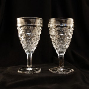 May include: Two clear glass goblets with a diamond pattern. The goblets have a hexagonal base and a wide bowl.