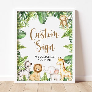 May include: A white framed sign with a green jungle theme. The sign has the text 'Custom Sign' in gold lettering. The sign also has the text 'We Customize You Print'. The sign is decorated with green leaves, a monkey, a zebra, a lion, an elephant, and a giraffe.
